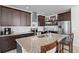 Modern kitchen featuring granite countertops, stainless steel appliances, a kitchen island, and dark wood cabinets at 4670 Tanner Peak Trl, Brighton, CO 80601