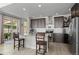 Charming kitchen featuring wooden cabinets, stainless steel appliances, a kitchen island with barstool seating and a sliding glass door at 4670 Tanner Peak Trl, Brighton, CO 80601