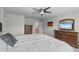 A cozy primary bedroom with carpet floors, a ceiling fan, and traditional wood furnishings at 4670 Tanner Peak Trl, Brighton, CO 80601