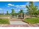 Community playground with modern play equipment, rock climbing features, and wood chip safety groundcover at 4670 Tanner Peak Trl, Brighton, CO 80601