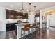 Modern kitchen with dark cabinets, granite island, and stainless steel appliances at 15162 Jakarta Cir, Parker, CO 80134