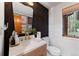 Stylish powder room featuring modern fixtures, dark wood wall accents, and a nature view at 110 Windwood Cir, Breckenridge, CO 80424