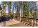 Outdoor deck with grill surrounded by lush trees at 110 Windwood Cir, Breckenridge, CO 80424