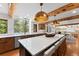 Bright, modern kitchen with a large island, stainless steel appliances, and a scenic wooded view at 110 Windwood Cir, Breckenridge, CO 80424