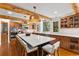 Well-lit kitchen featuring a large island with seating, wooden cabinets, stone countertops and stainless appliances at 110 Windwood Cir, Breckenridge, CO 80424