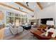 Bright living room features vaulted ceilings, stone fireplace, large windows, and comfortable seating at 110 Windwood Cir, Breckenridge, CO 80424
