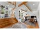 Elegant staircase opens to the living room with stone fireplace, beamed ceilings, and comfortable seating at 110 Windwood Cir, Breckenridge, CO 80424