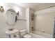 Bright bathroom featuring a pedestal sink, oval mirror, and a tiled shower-tub combination at 3854 S Dayton Way # 308, Aurora, CO 80014