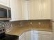 A kitchen with stainless appliances and white cabinetry with a tiled backsplash at 3854 S Dayton Way # 308, Aurora, CO 80014