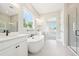 Bright bathroom featuring a freestanding tub, double vanity, and glass enclosed shower at 5909 S Platte Canyon Dr, Littleton, CO 80123