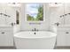 Bright bathroom with modern tub, fixtures, dual vanities and natural light at 5909 S Platte Canyon Dr, Littleton, CO 80123