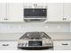 Close-up of the stainless steel range and microwave in the modern kitchen at 5909 S Platte Canyon Dr, Littleton, CO 80123