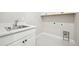 Bright and spacious laundry room with stainless steel sink and modern white cabinets at 5909 S Platte Canyon Dr, Littleton, CO 80123