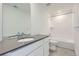 Bright bathroom with a sleek vanity, a large mirror, and a tiled shower-tub combination at 2094 S Haleyville Way, Aurora, CO 80018
