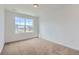 Carpeted bedroom featuring a bright window, white walls and baseboards, and an electrical outlet at 2094 S Haleyville Way, Aurora, CO 80018