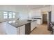 Stylish kitchen with large island with stainless steel sink, dark countertops, white cabinets and hardwood floors at 2094 S Haleyville Way, Aurora, CO 80018