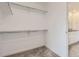 Walk-in closet with carpet, shelving and poles for storage, and doorway into bathroom at 2094 S Haleyville Way, Aurora, CO 80018
