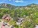 Aerial view of a home nestled amongst trees with stunning mountain views in the background at 1029 9Th St, Boulder, CO 80302