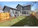 Backyard view of a modern home featuring a lush, green lawn with a wooden fence and a patio at 1149 S Madison St, Denver, CO 80210