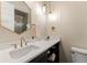 Elegant bathroom with a modern vanity, gold fixtures, and hexagon mirror at 1149 S Madison St, Denver, CO 80210