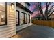 Exterior evening view featuring a patio with steps, rear siding and large windows and mature trees at 1149 S Madison St, Denver, CO 80210