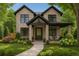 Charming two-story brick home with a beautifully landscaped front yard and inviting front porch seating area at 1149 S Madison St, Denver, CO 80210