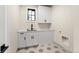 Bright laundry room with white cabinets and hexagon tile floor at 1149 S Madison St, Denver, CO 80210