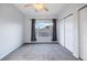 Neutral bedroom features a ceiling fan, a large window with curtains, and a closet with sliding doors at 3857 Mossy Rock Dr # 201, Highlands Ranch, CO 80126