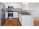 Modern kitchen featuring stainless steel appliances, white cabinetry, and granite countertops at 3857 Mossy Rock Dr # 201, Highlands Ranch, CO 80126