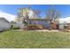 The backyard has a well-maintained lawn, a wooden deck, and a gray house exterior at 11506 Fowler Dr, Northglenn, CO 80233
