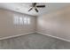 This bedroom features neutral carpet, a ceiling fan, and a window with plantation shutters at 11506 Fowler Dr, Northglenn, CO 80233