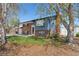 Well-kept two-story brick and blue wood home with green lawn and mature trees at 11506 Fowler Dr, Northglenn, CO 80233