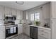 Well-lit kitchen features stainless appliances, white cabinets and subway tile at 11506 Fowler Dr, Northglenn, CO 80233
