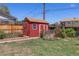 Backyard including a red shed with white trim and a brown roof at 11506 Fowler Dr, Northglenn, CO 80233