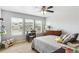 Sunlit bedroom with neutral carpet, a ceiling fan and featuring a bed, dresser and desk with a street view at 2307 Candleglow St, Castle Rock, CO 80109