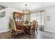 Dining room featuring hardwood floors, a wooden table with chairs, a hutch, and a modern chandelier with natural light at 2307 Candleglow St, Castle Rock, CO 80109