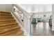 Hallway with carpeted stairs leading to an open floor plan with view into living and dining areas with hardwood floors at 2307 Candleglow St, Castle Rock, CO 80109