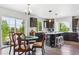 Modern kitchen with dark cabinetry, a center island, and a dining area with large windows at 2307 Candleglow St, Castle Rock, CO 80109