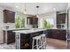 Modern kitchen with dark cabinets, island with white countertop, and stainless steel appliances at 2307 Candleglow St, Castle Rock, CO 80109