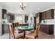 Bright kitchen featuring dark cabinets, stainless appliances, and eat-in dining area at 2307 Candleglow St, Castle Rock, CO 80109