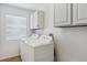Clean laundry room with white cabinets and a window, featuring a modern washer and dryer set at 2307 Candleglow St, Castle Rock, CO 80109