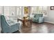 Cozy living room featuring blue sofas, a unique coffee table, and hardwood floors, enhanced by natural light from the windows at 2307 Candleglow St, Castle Rock, CO 80109