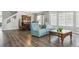 Open-concept living room with hardwood floors, blue sofas, and view into dining area with a wooden table and chairs at 2307 Candleglow St, Castle Rock, CO 80109