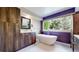 Modern bathroom featuring a freestanding tub, a sleek vanity with ample storage, and a bright window with a lush view at 2990 E 135Th Dr, Thornton, CO 80241