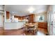 Bright dining area with hardwood floors, a round wooden table, and a view of the modern kitchen at 2990 E 135Th Dr, Thornton, CO 80241