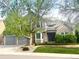 Charming two-story home with brick and gray siding, mature trees, manicured lawn, and an attached two-car garage at 2990 E 135Th Dr, Thornton, CO 80241