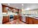 Modern kitchen with stainless steel appliances, custom wood cabinetry, granite countertops, and hardwood flooring at 2990 E 135Th Dr, Thornton, CO 80241