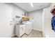 Well-organized laundry room with sink, storage, and modern appliances for convenient chores at 2990 E 135Th Dr, Thornton, CO 80241