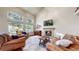 Spacious living room with high ceilings, a cozy fireplace, large windows and comfortable furnishings at 2990 E 135Th Dr, Thornton, CO 80241