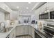 A modern kitchen with stainless steel appliances, stylish cabinetry, and stone countertops overlooks an open living area at 4929 W 73Rd Ave, Westminster, CO 80030